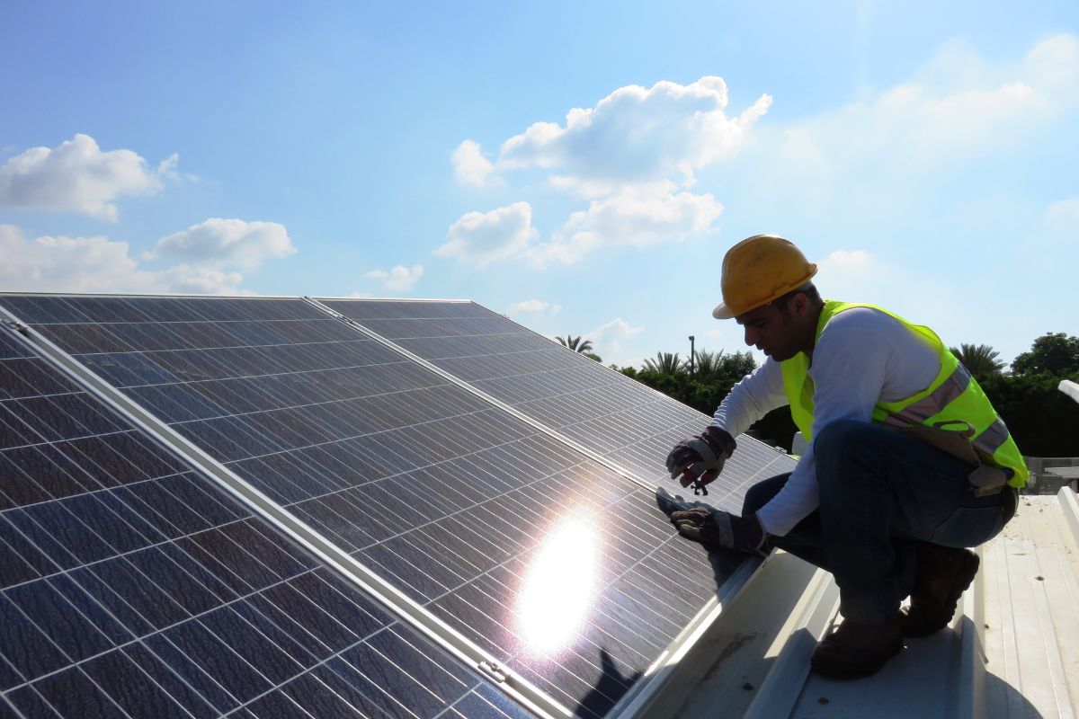 A technician installing environmentally sustainable solar roof panels